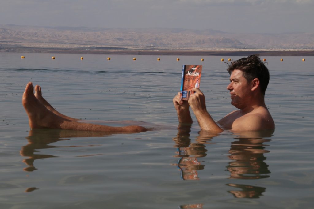 Floating with our Jordan Lonely Planet in the Dead Sea