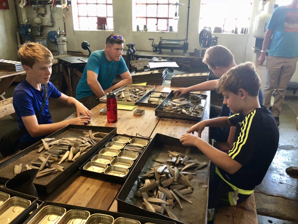 Filling tins with sardines at the Norwegian Caning Museum in Stavanger