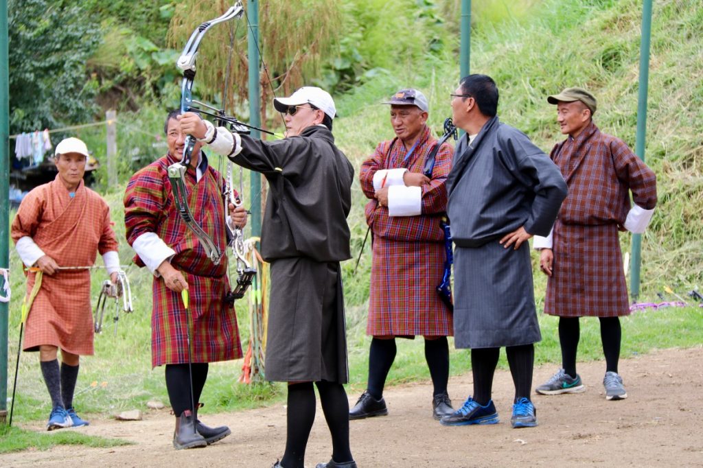 Men playing archery in traditional dress in Bhutan